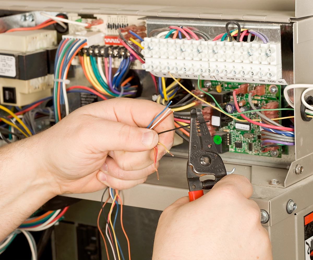 A person is working on an electrical panel.