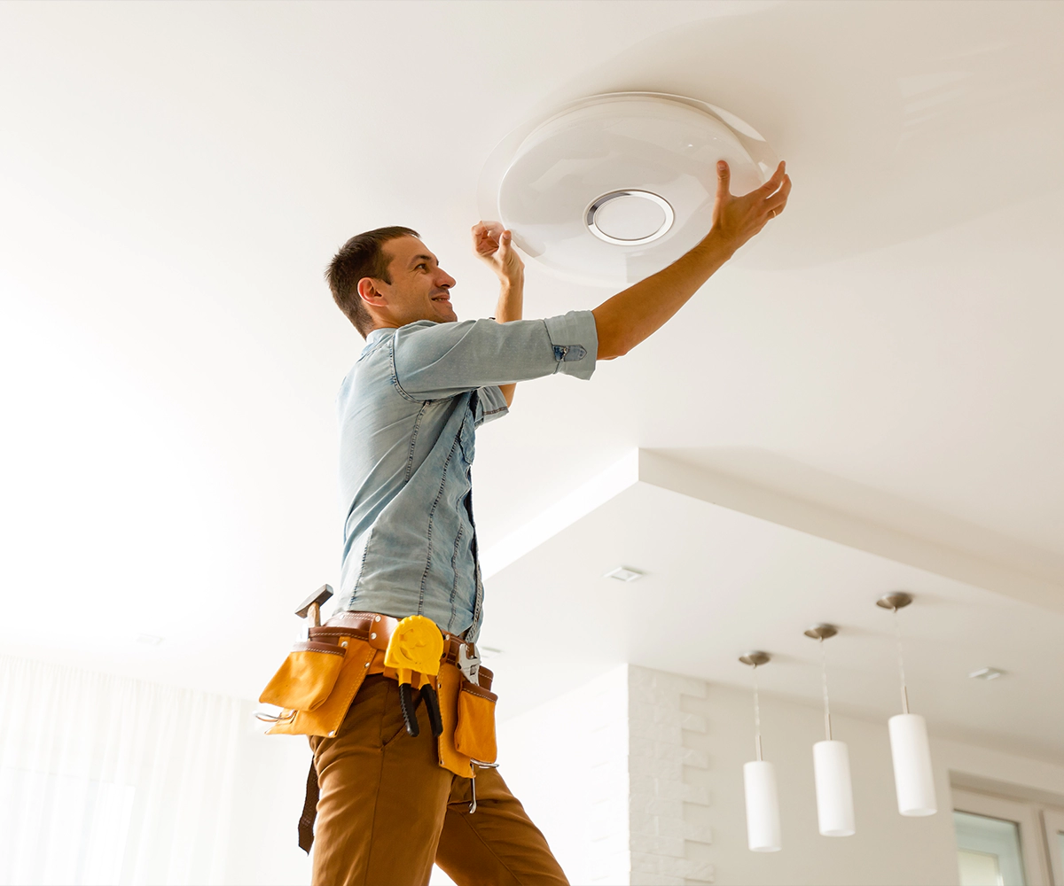 A man is fixing the ceiling of his home.