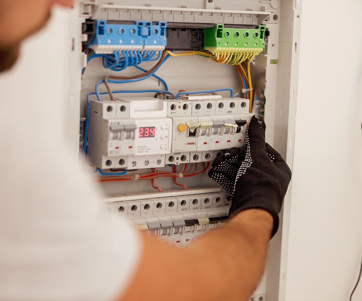 A person is working on an electrical panel.