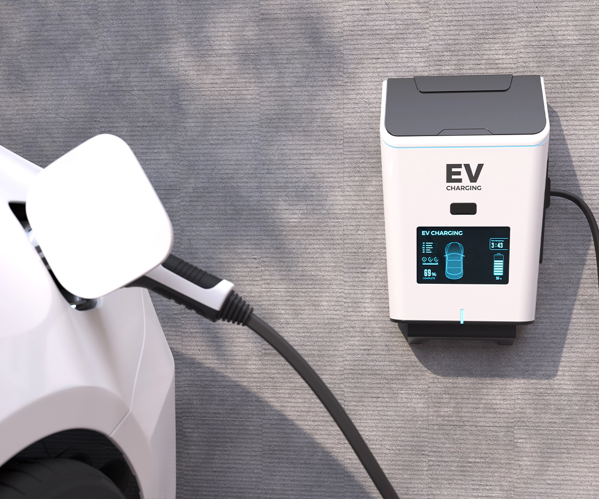 A white electric car charging on the side of a road.