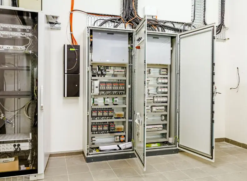 A large electrical panel with many wires hanging from it.